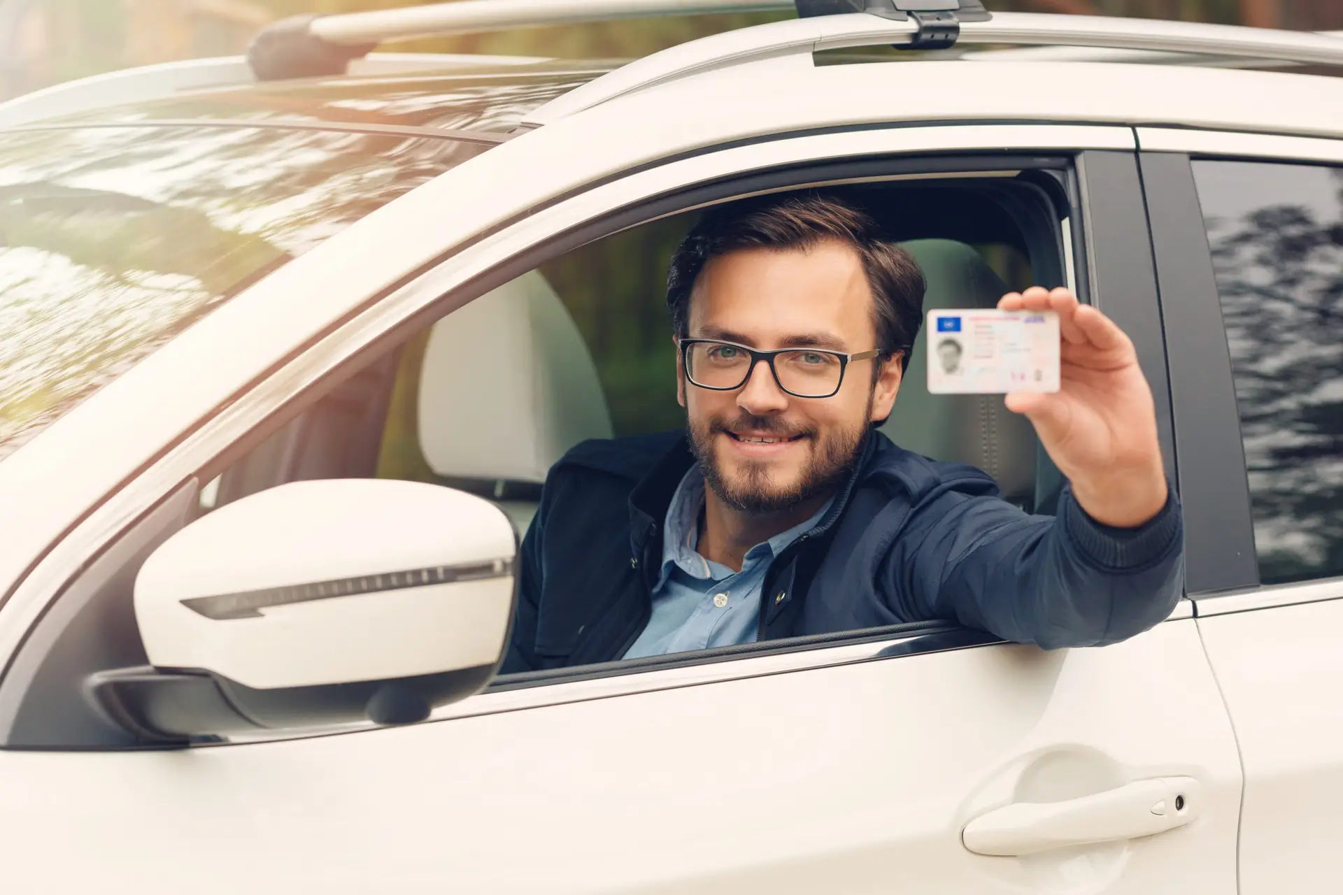 Man in car showing his driving licence through the window